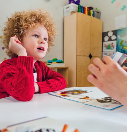Teacher spreads out puzzle in front of the child