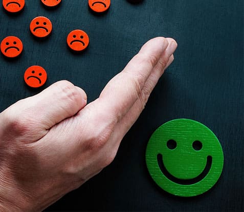 hand protects the joyful emoticon from the sad ones
