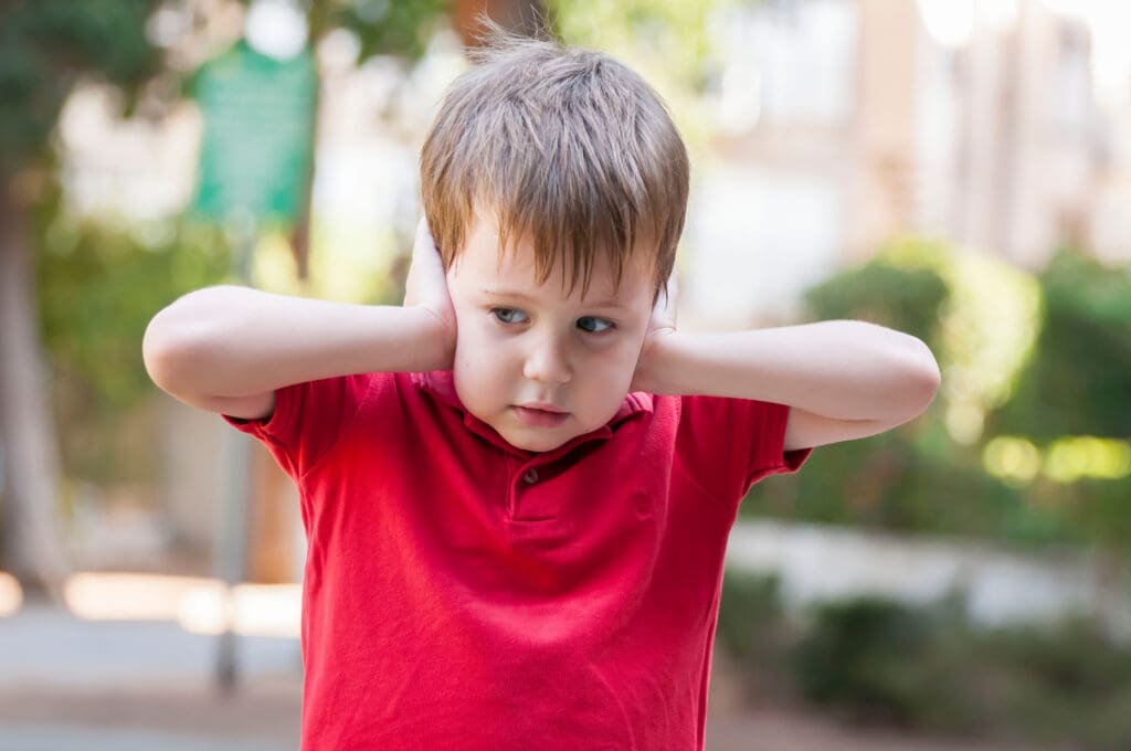 boy closing ears with his hands
