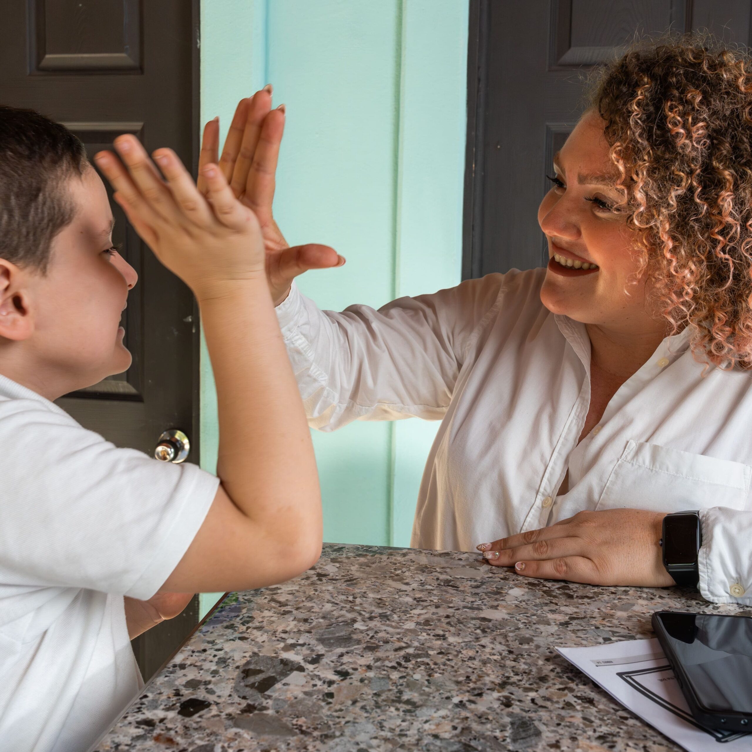 Boy Sharing a High-Five with His Mother at Home